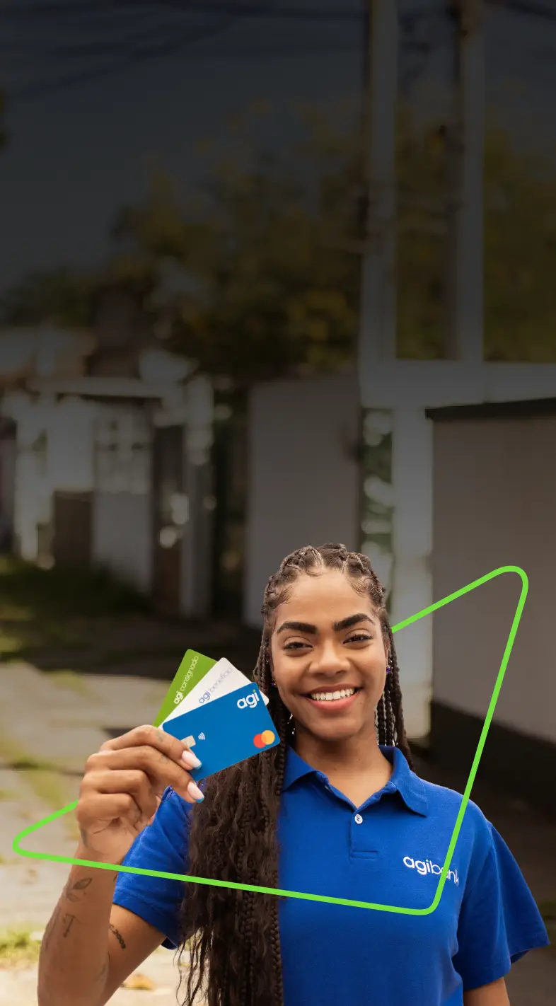 Mulher com camisa azul, segurando três cartões do Agibank