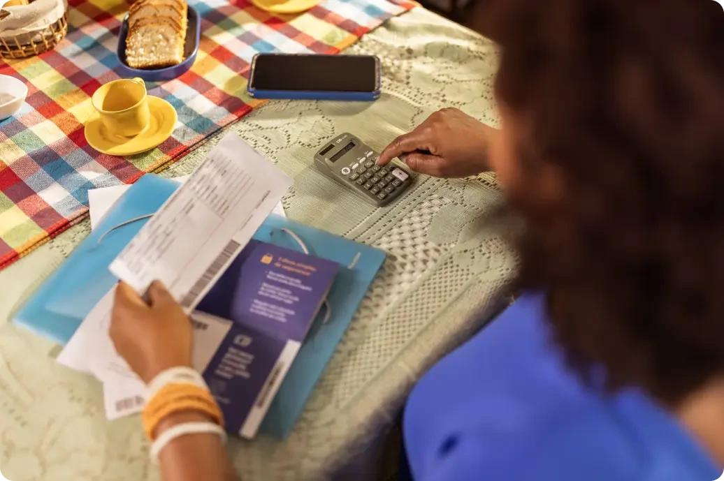Mulher usando a calculadora para calcular as despesas do dia a dia.